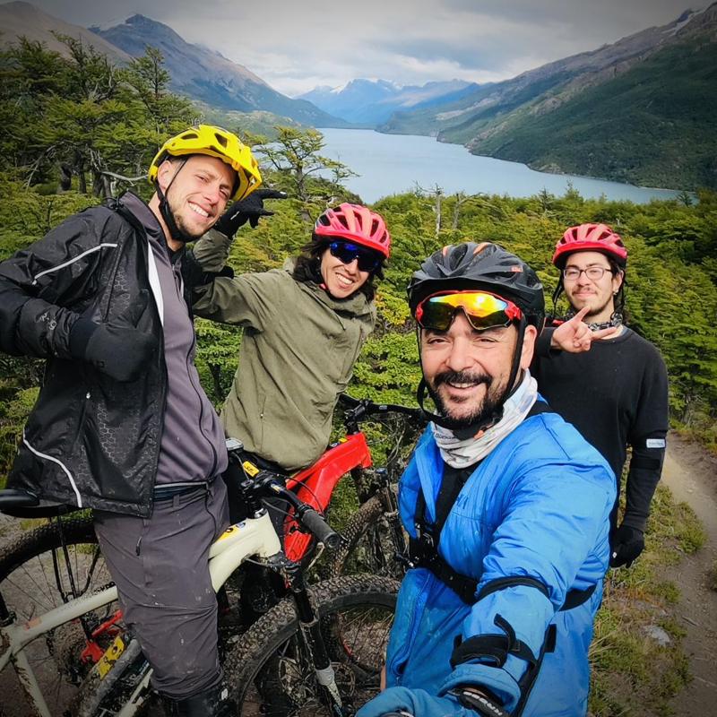Un grupo de ciclistas con cascos junto al Lago del Desierto