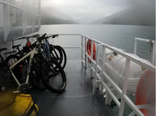 Bicicletas en la cubierta de una embarcación, con el lago cubierto de niebla